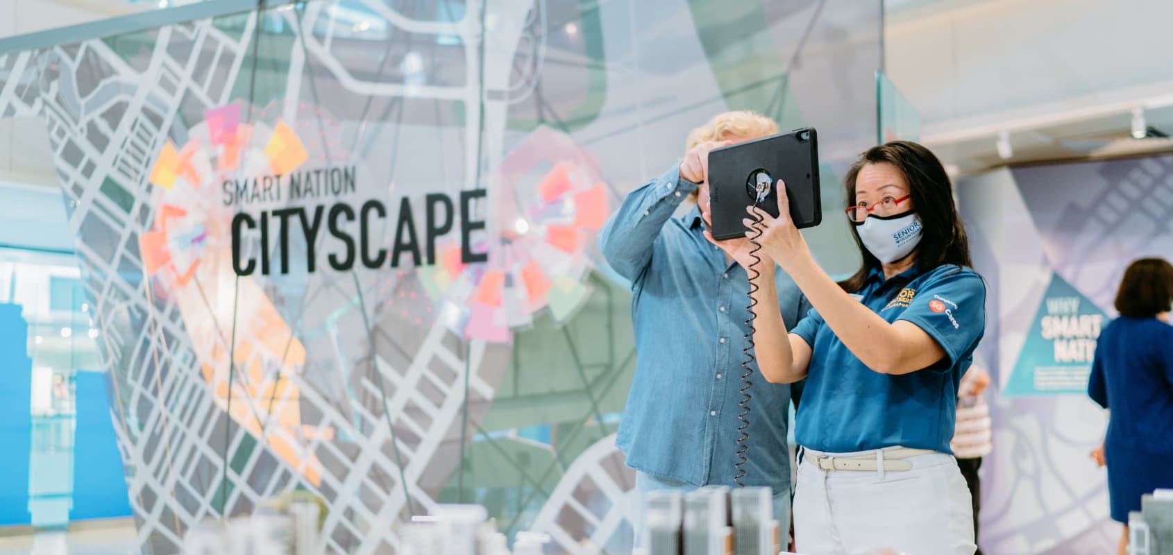 Smart Nation Cityscape: An employee showing a visitor the latest developments via an iPad